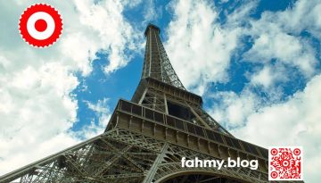 Das Foto zeigt den Eiffelturm in Paris von einer schrägen Froschperspektive aus. Der Eiffelturm scheint nicht gegen sondern in den Himmel zu ragen. Das rot-weiß-rote Logo von fahmy.blog ist in der linken oberen Ecke, der QR-Code und Bildunterschrift von fahmy.blog ist in der rechten Ecke zu sehen.
