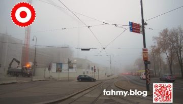 Ende November 2020. Das österreichische Parlament im Umbau. Es ist früh am Morgen. Überall dichter Nebel. Das Parlament ist in nahezu undurchsichtigem Nebel getüncht. Ebenso der angrenzende Ring. Die Pallas Athene kann man hinter den Pallisaden der Großbaustelle erahnen. Nur die Scheinwerfer des Morgenverkehrs, die Signalleuchte am Kranwagen dringen durch den Nebel. Das Bild heißt Baustelle und illustriert den Beitrag Democrazy. Das rot-weiß-rote Logo von fahmy.blog ist in der linken oberen Ecke, der QR-Code und Bildunterschrift von fahmy.blog ist in der rechten Ecke zu sehen.